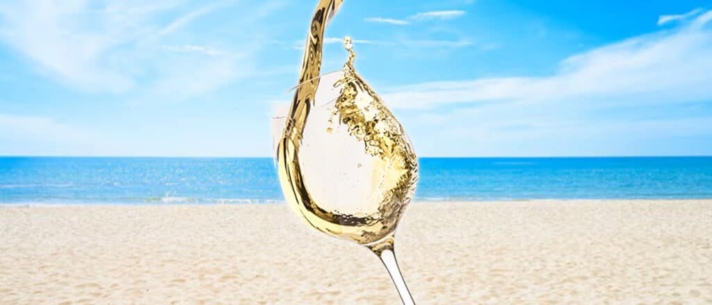 Chilled glass of white wine served outdoors in Cyprus summer heat with seafood and salad pairing.