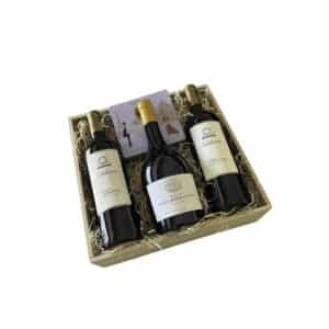 Wooden rectangular gift tray with two bottles of Valduero Reserva red wine, one Pazo Barrantes Albariño white wine, and assorted chocolates.