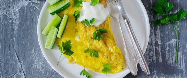 Omelette with parsley, served with sour cream and fresh cucumber.